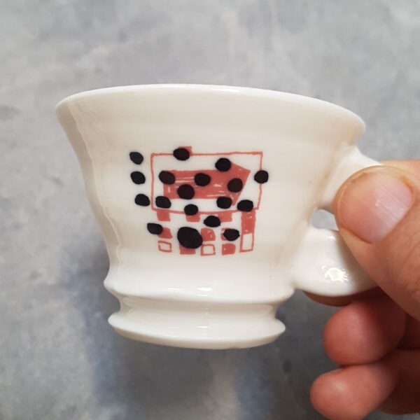 Espresso-Tasse, schwarze Punkte und Pfeil